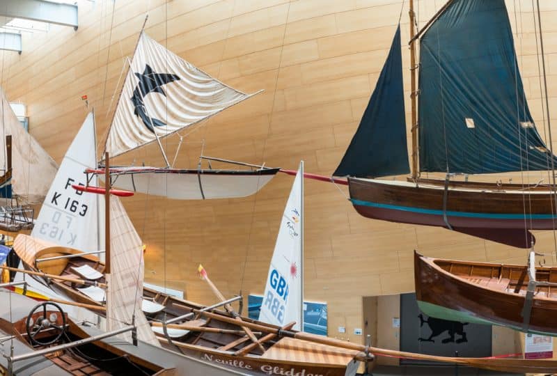 A panorama photo of the flotilla of small boats displayed hanging from the ceiling of the Museum's Main Hall.