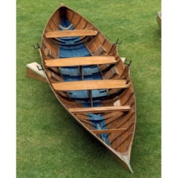 A photo of the Thames wherry positioned on grass.