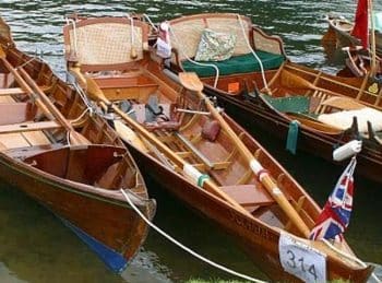 A photo of three Thames skiffs moored alongside one another.