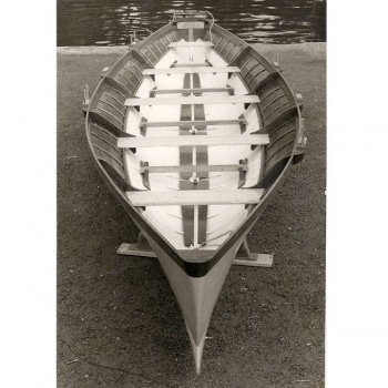 A black and white photo of a Cornish flashboat resting on a stand.
