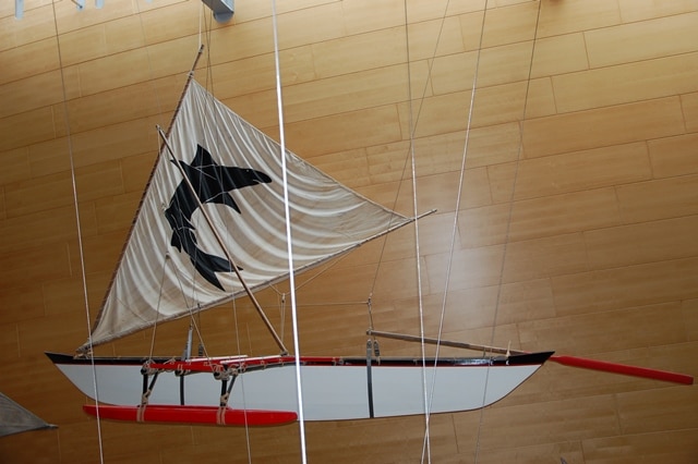 Photo of the Gilbert Islands Outrigger, suspended from the ceiling of the Museum's Main Hall.