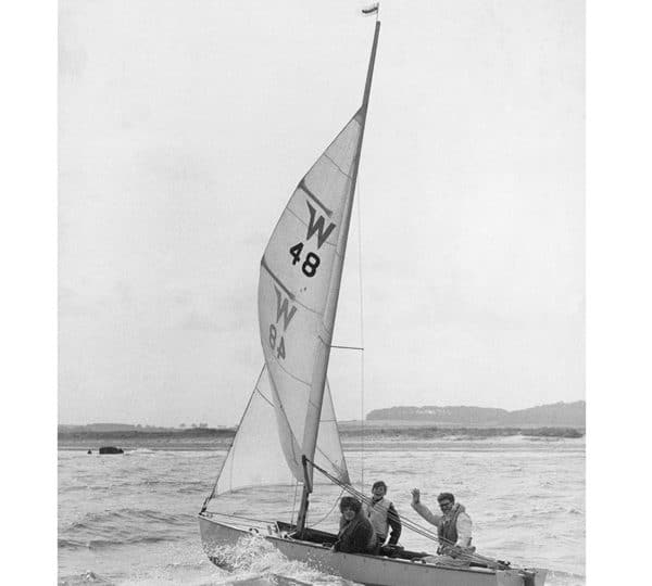 A black and white photo of three men in the 'Wanderer'. One is waving at the camera.