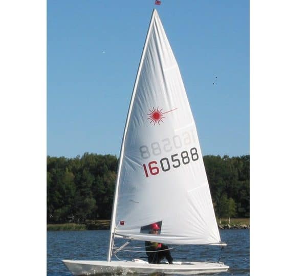 A side-on photo of a man sailing in a Laser dinghy.