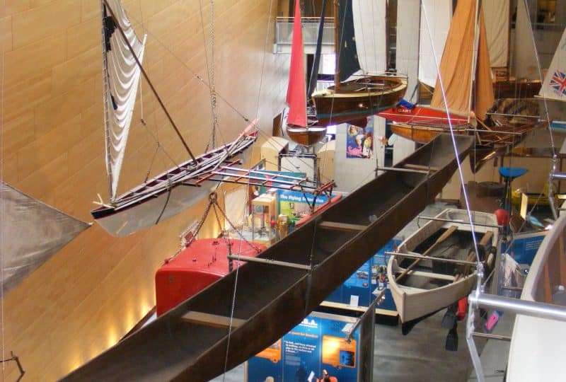 A photo of the Piroga canoe suspended from the ceiling above the Museum's Main Hall.