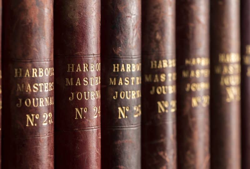 A close-up photo of the spines of six Harbour Masters Journals. The books are numbered from 23 to 28.