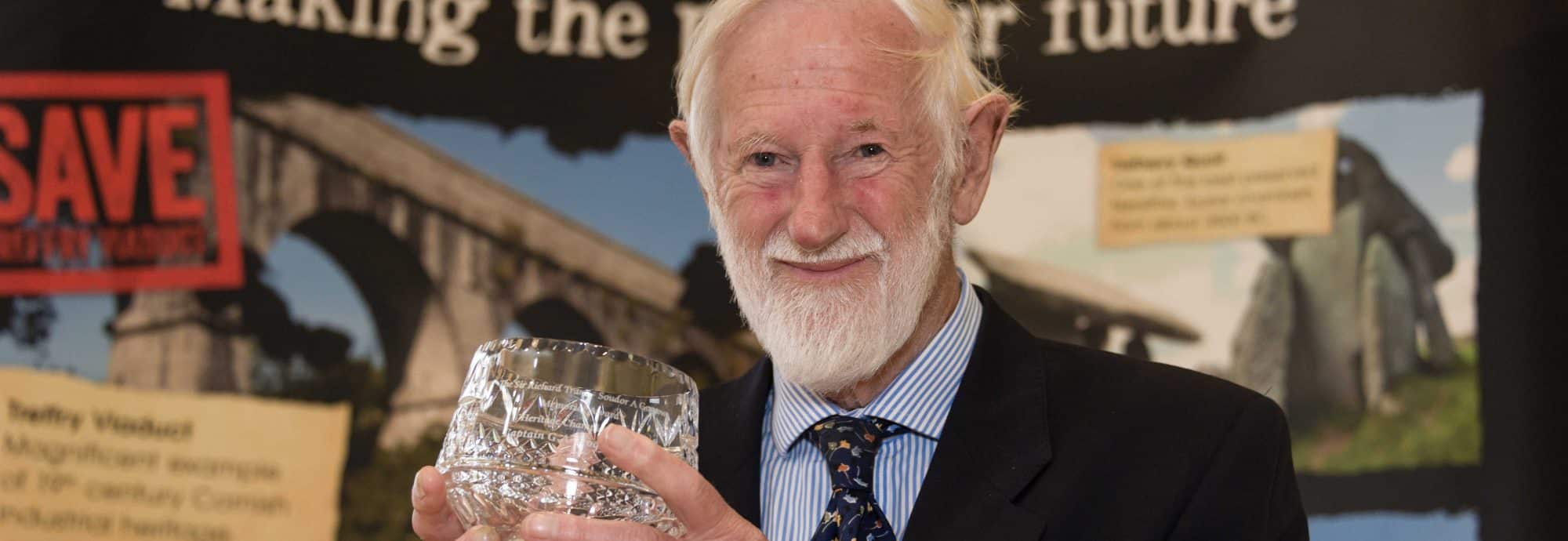 Captain George Hogg holds the 'Sir Richard Trant Memorial Award for Heritage Champion' trophy.