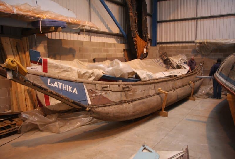 A photo of the 'Lathika' outrigger canoe, partially covered by a tarpaulin.