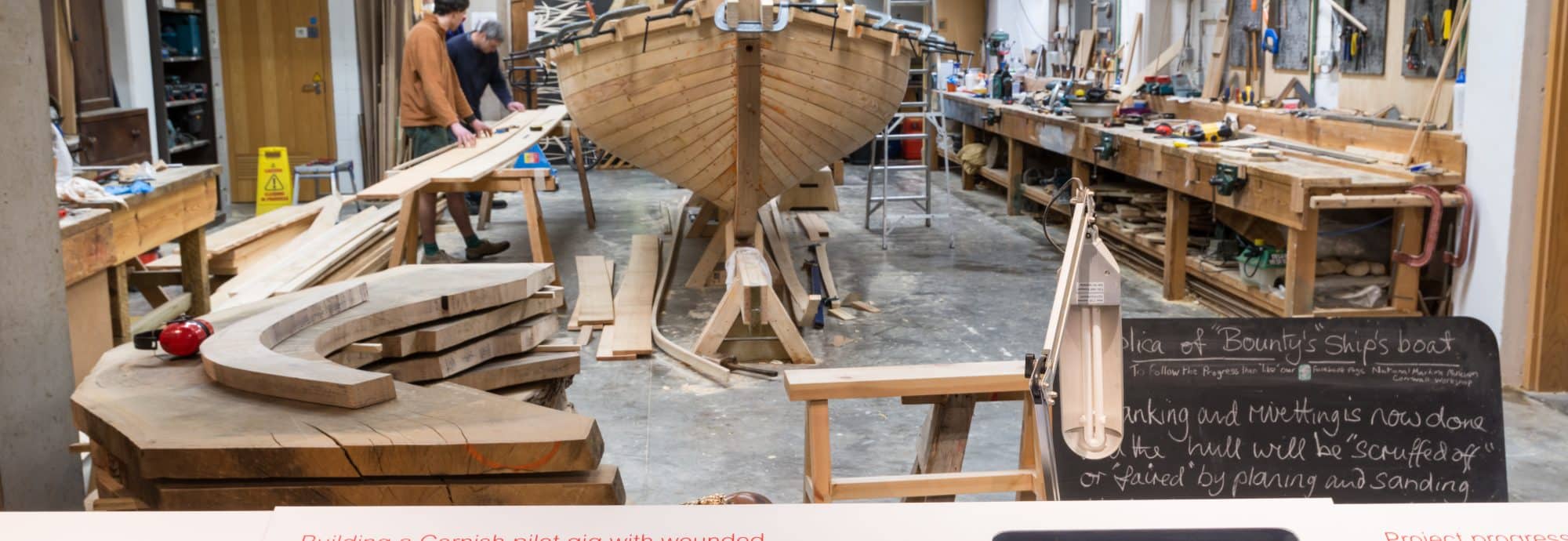 A photo of the wooden frame of a boat being worked on in the Museum's workshop.