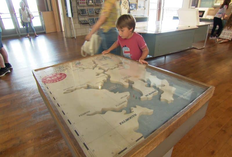 A photo of a young boy examining a 3D map of Falmouth harbour and the River Fal in the Museum's Nav Station.