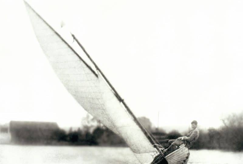 Black and white photo of a man sailing the 'Nomad'.