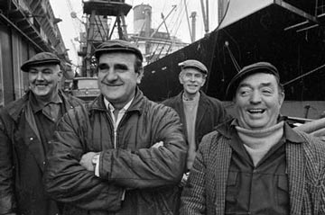Black and white photo of four male dock workers.