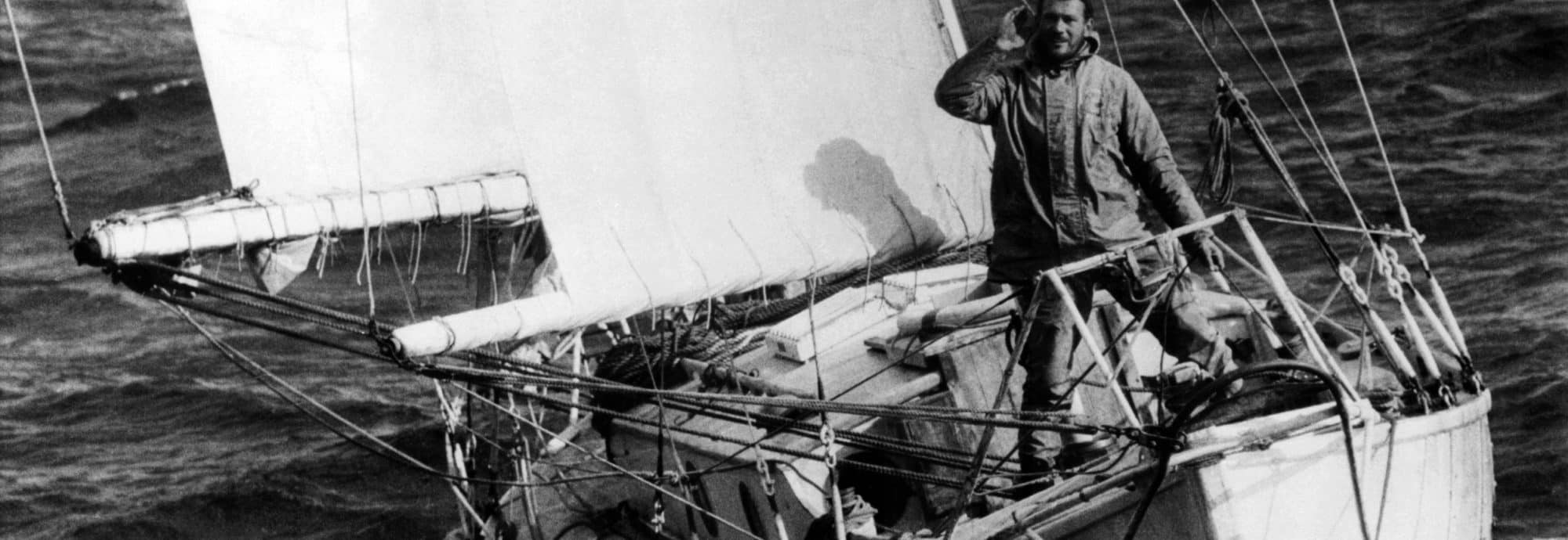 A black and white photo of Sir Robin Knox Johnston onboard his vessel.