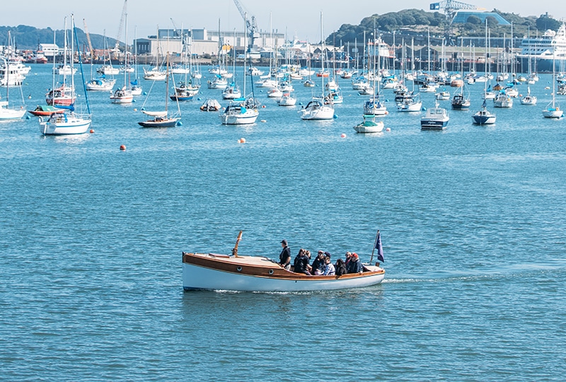 A small boat sails across Falmouth harbour.