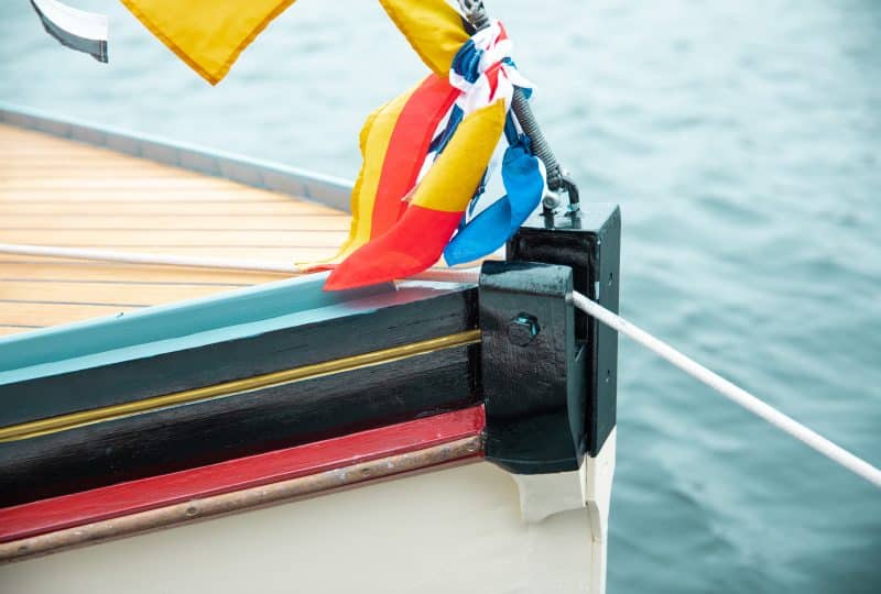 Close-up photo of some flags tied to the rope that attaches the sail to the bow of 'Sea Queen'.