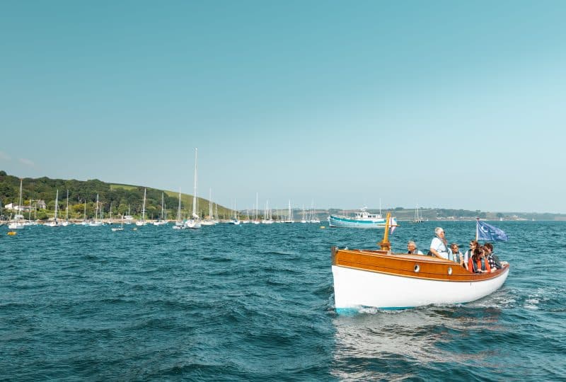 A boat carries passengers across Falmouth harbour.