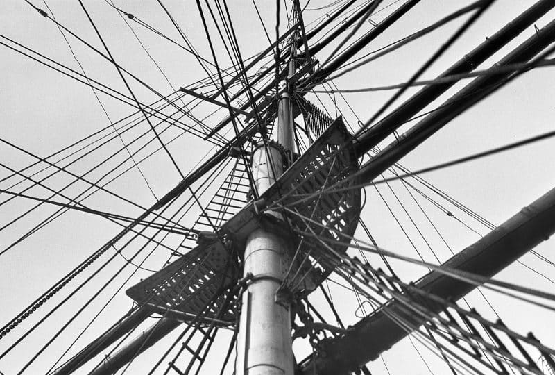 A black and white photo looking up from the deck of the Cutty Sark to the top of its mast.