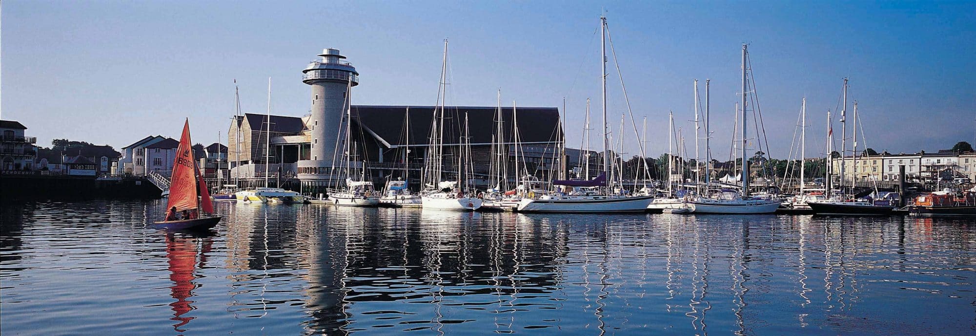 Photo of the exterior of the Museum, taken across the water with the marina in front of it.