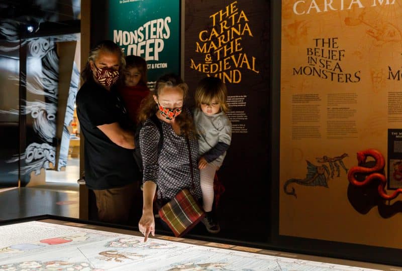 A man, a woman and two young children examine an object in the Museum's 'Monsters of the Deep' exhibition.