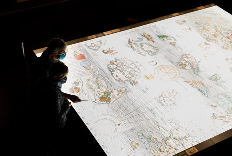 Photo of two visitors examining a large map in the Museum's 'Monsters of the Deep' exhibition.