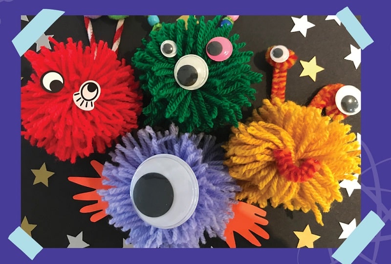 Photo of four 'pom pom aliens' made from pom poms and googly eyes.