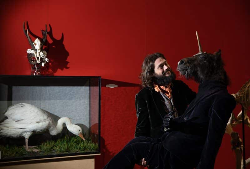 Viktor Wynd installs part of his UnNatural History Museum pop-up exhibition - a figure in a black suit with a human torso but a unicorn's head.