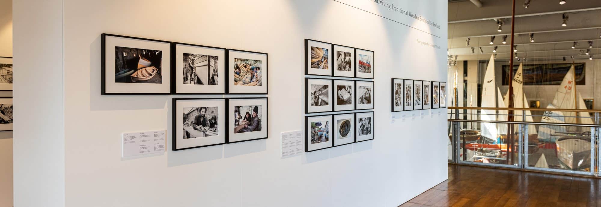 A wall of framed photos on display as part of the Museum's 'Hegarty’s Boatyard' exhibition.