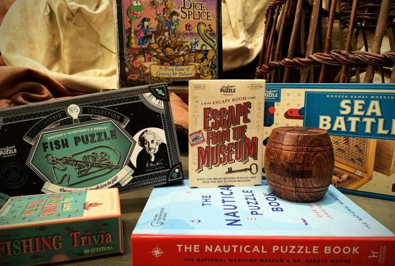 A photo of a selection of products from the shop, including a puzzle, a book and a game.