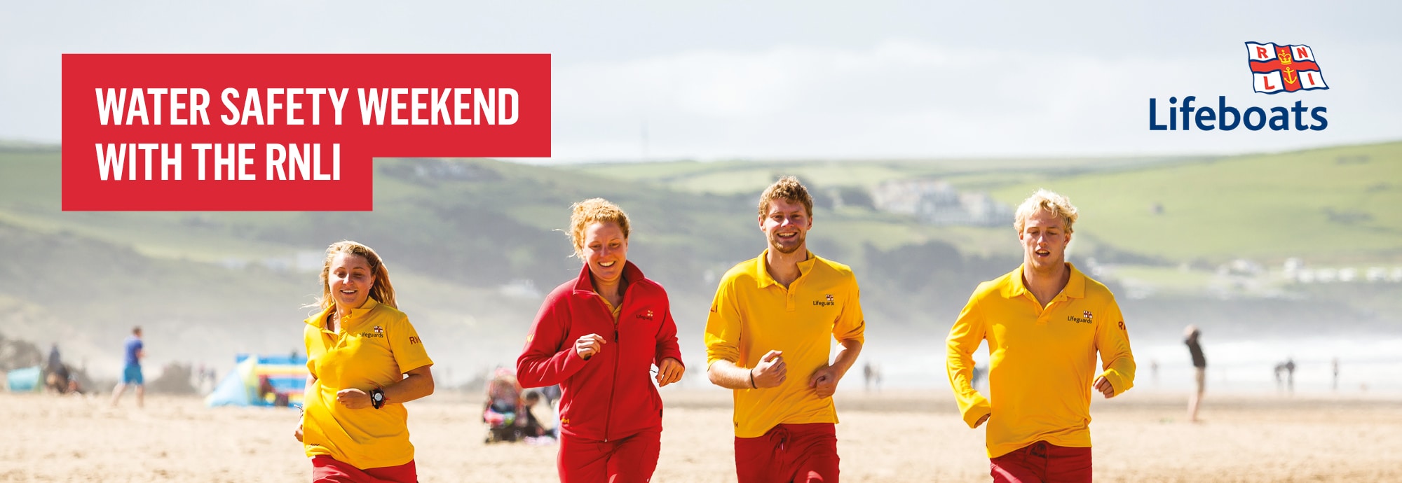 In the top left is a red box with the text 'water safety weekend with the RNLI'. In the top right is the RNLI Lifeboats logo. The main feature of the image is four lifeguards running along a beach.