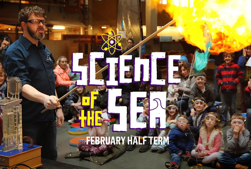 Text at the top reads 'Science of the Sea'. Underneath, a man performs an experiment in front of a crowd of children.