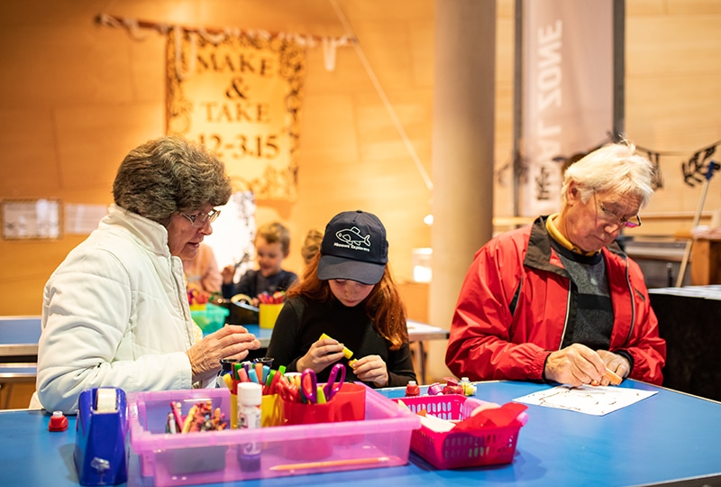 A couple and their granddaughter take part in a craft session.