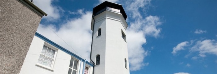 Photo looking up at the Observatory Tower in Falmouth, against a blue sky.