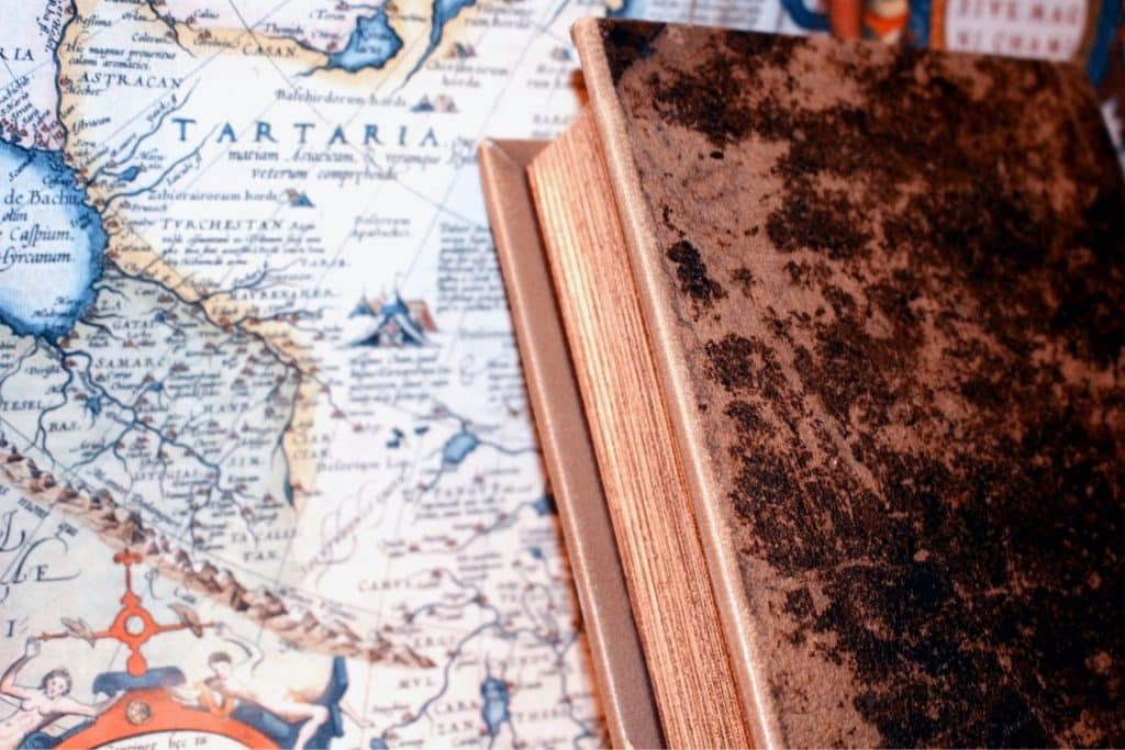 A close-up photo of the corner of an old book against a map.