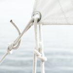 A close up image of the knotted rope tying a sail to the frame of a ship.