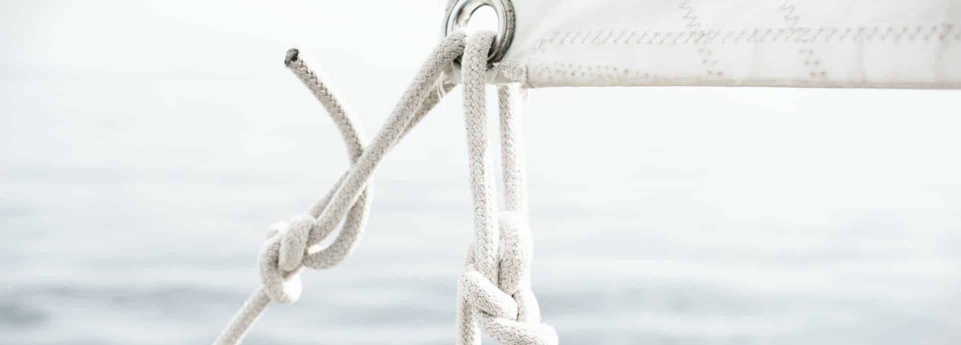 A close up image of the knotted rope tying a sail to the frame of a ship.