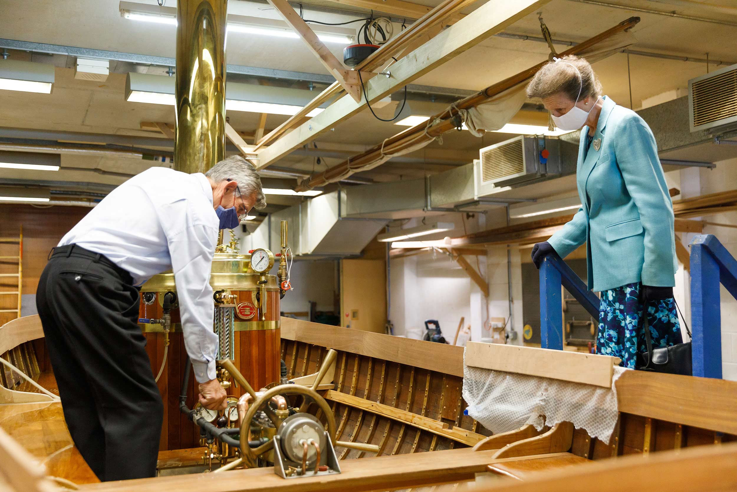 Princess Anne is shown a boat being worked on in the Museum's workshop.