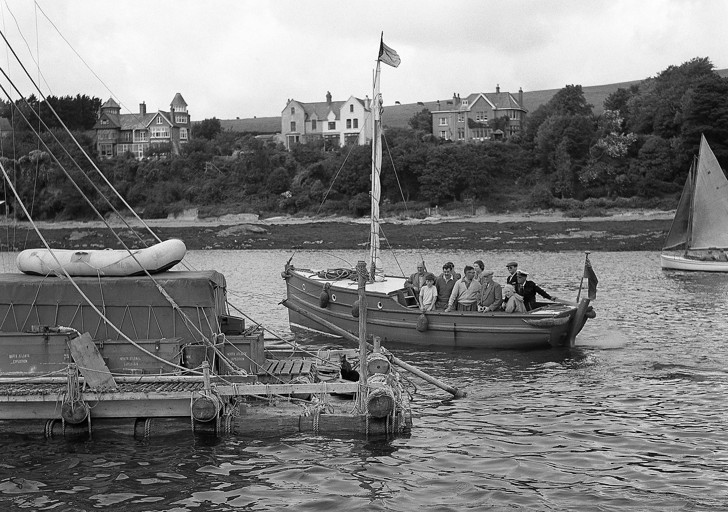 Black and white photo of the L'Egare and a boat carrying people who have come to have a look at it.