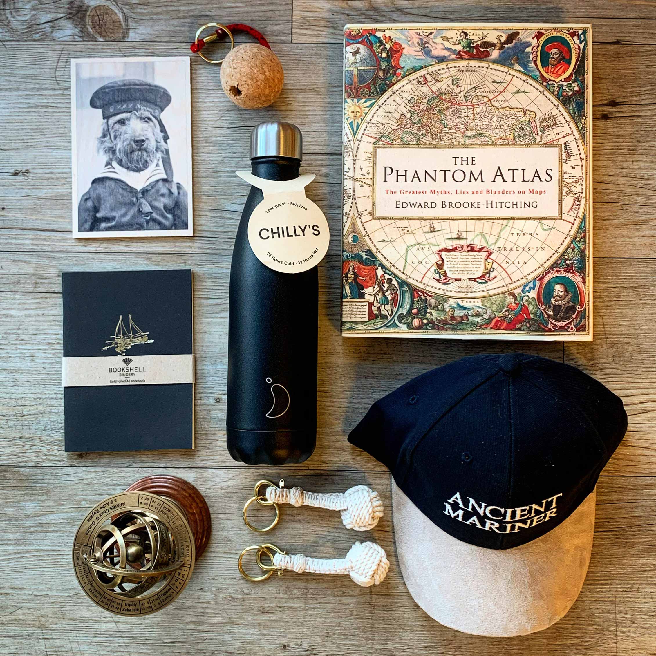 A photo of items from the Museum's shop laid out on a table. Items include a water bottle, a notebook, a cap and a book.