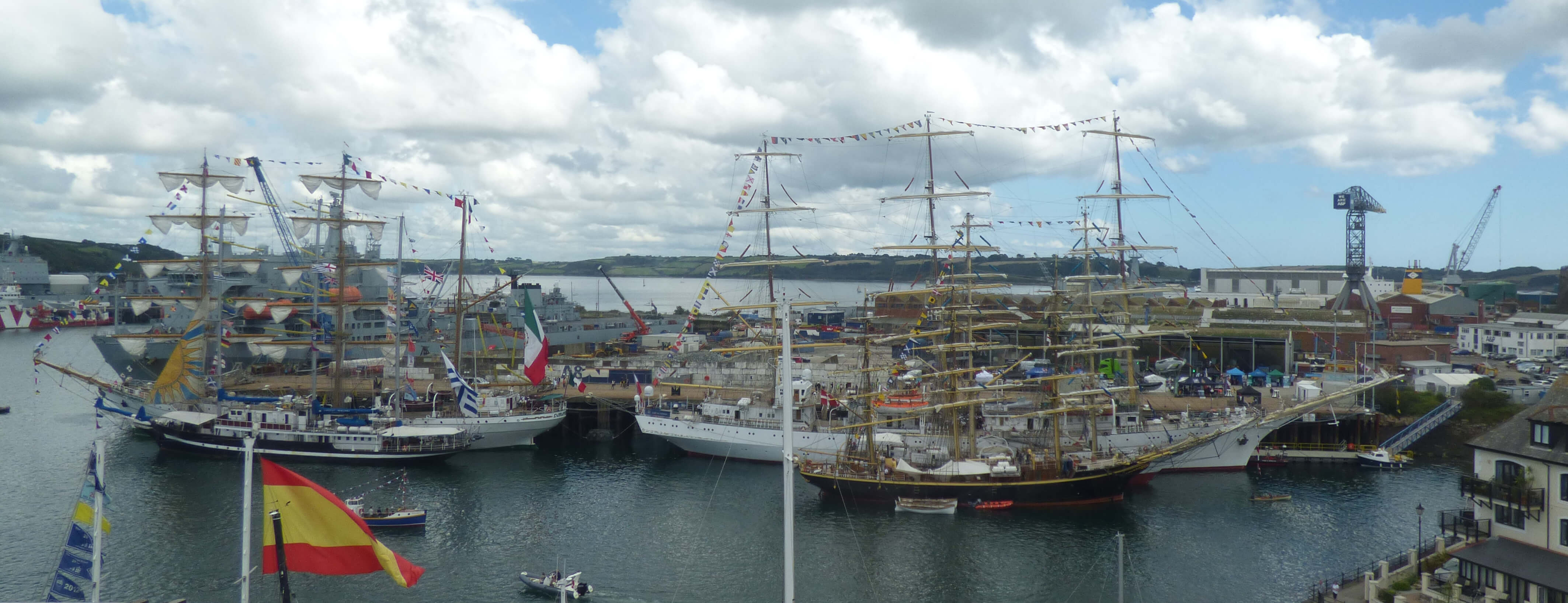 A photo of the Tall Ships stationed at A&P Falmouth Ltd at 2023's Falmouth Tall Ships event. The photo is taken from the top of the Lookout Tower at National Maritime Museum Cornwall.