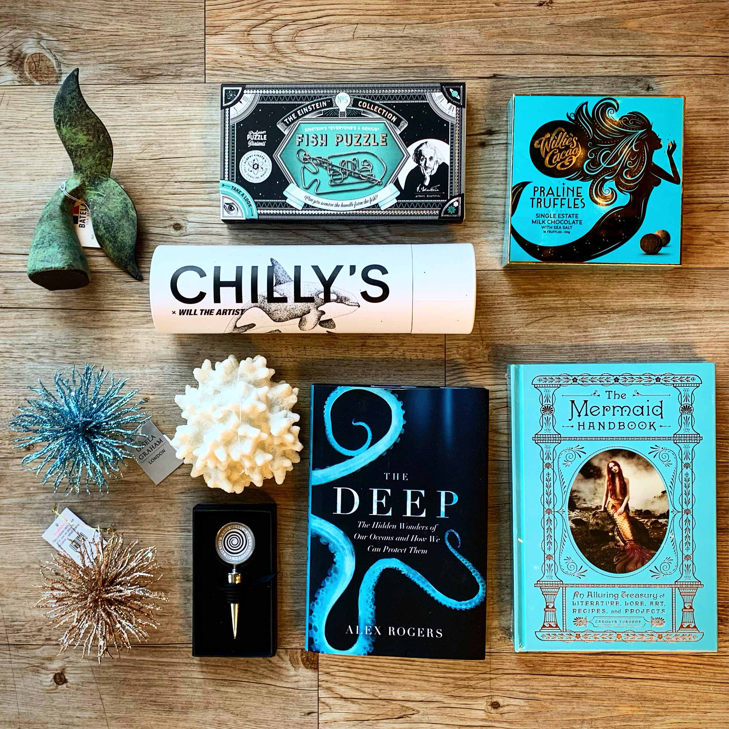 Photo of items from the Museum's shop laid out on a table. Items include books, a box of chocolates, and a water bottle.