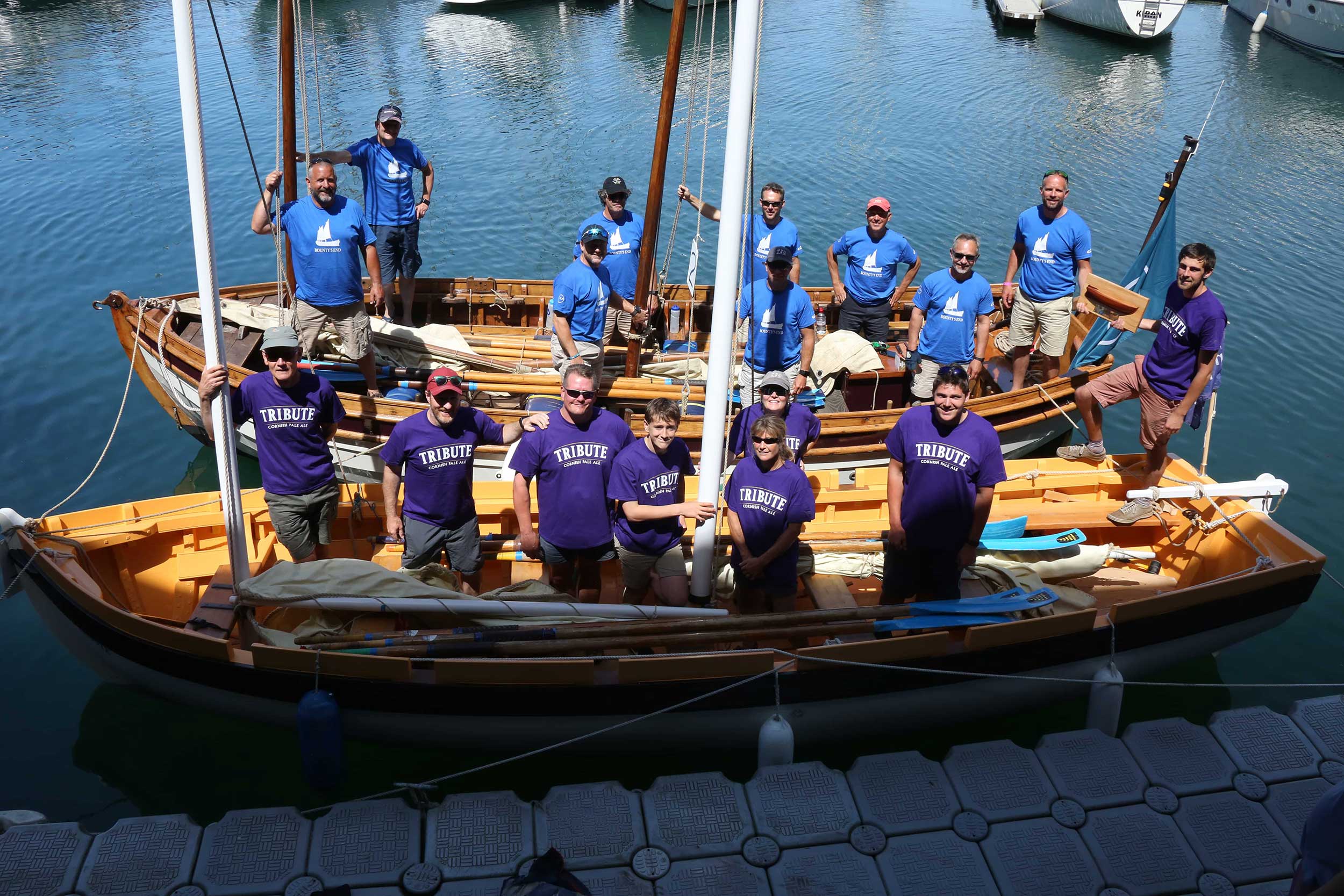 Photo of the 'Bounty's End' and 'Bligh's Tribute' boars moored side-by-side with their respective crews standing onboard, looking up at the camera.