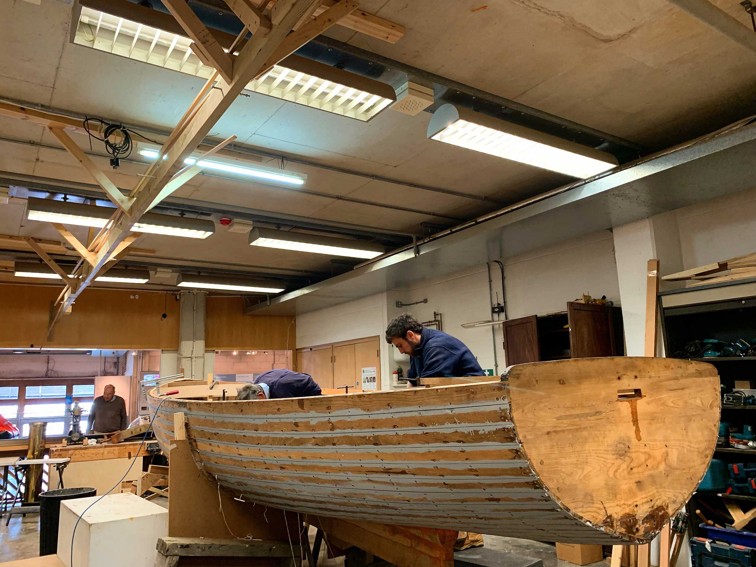 Boatbuilding volunteers at National Maritime Museum Cornwall working on the restoration of teak-built steam launch, 'Emma'.