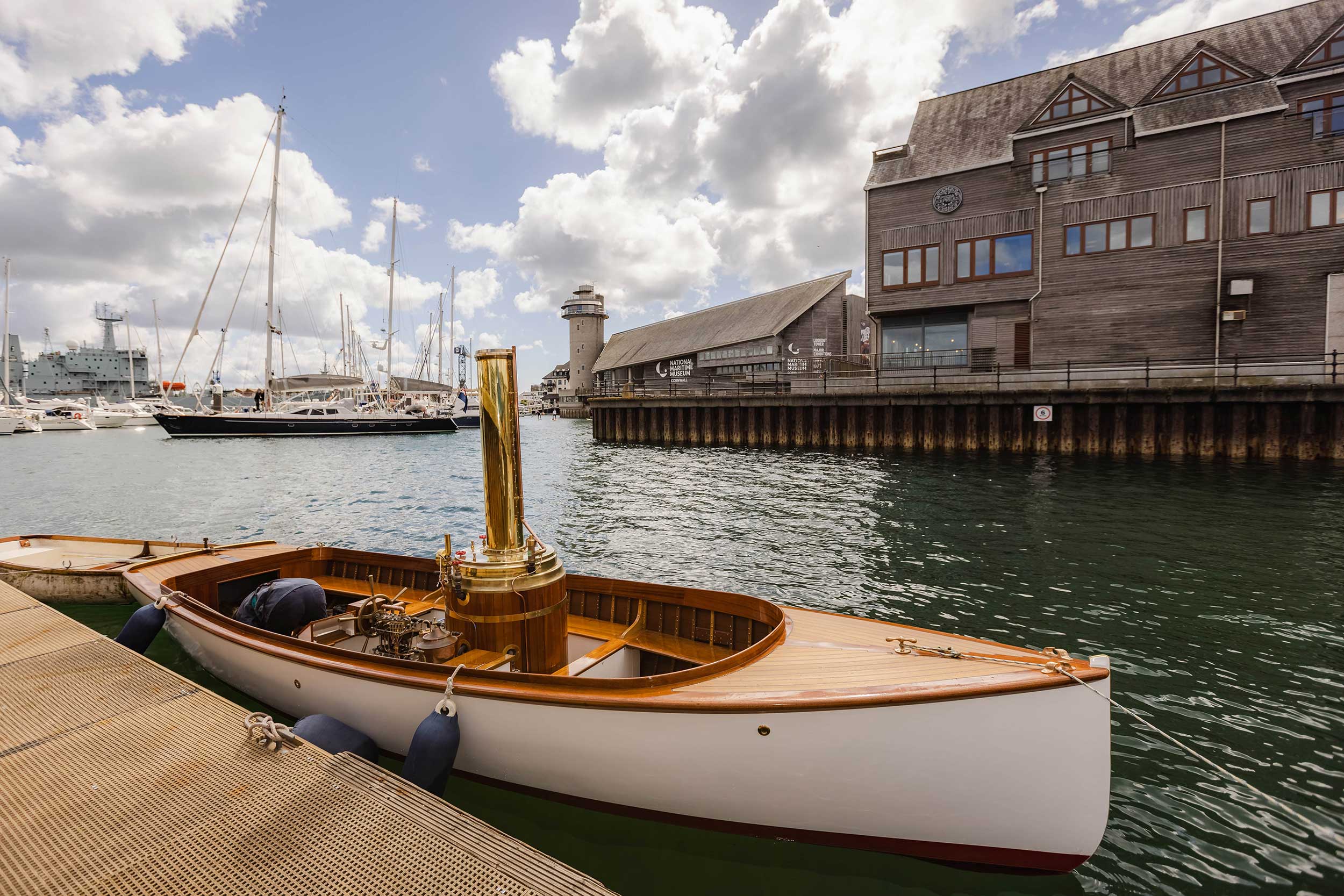 Photo of the steam launch Emma in the water with the Museum and part of Discovery Quay in the background.