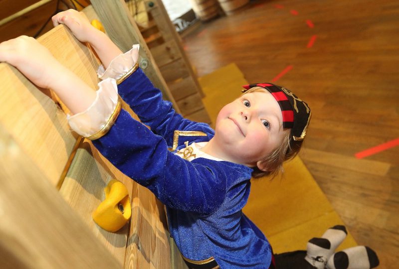 A child dressed in a pirate costume plays on the Museum's Treasure Island play zone.