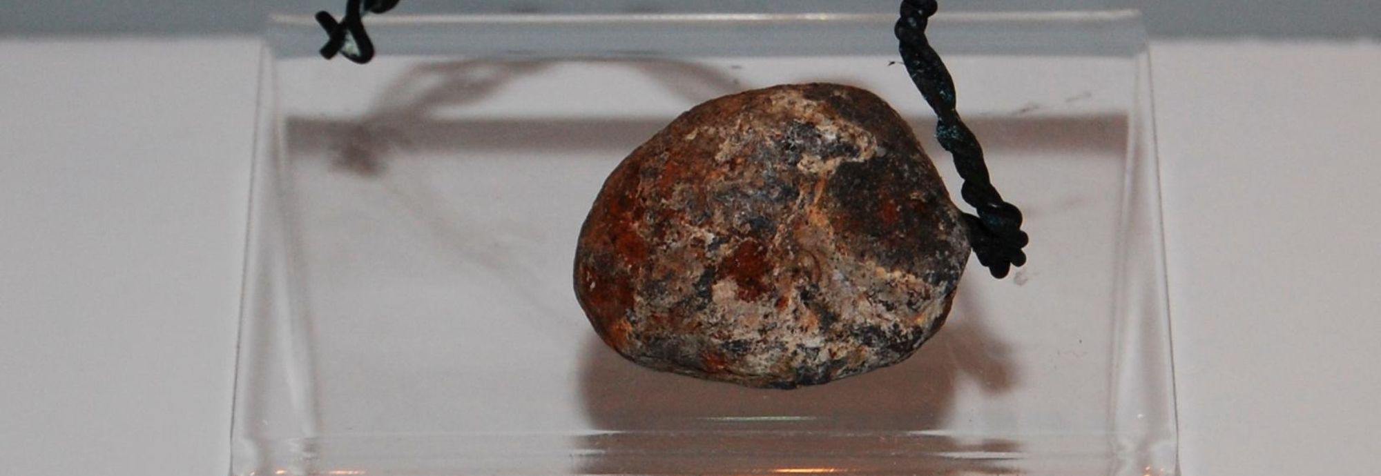 A photo of a lead grape shot recovered from the Hanover wreck. Pictured on a white surface.
