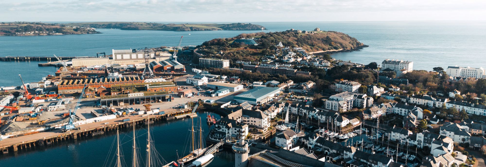 A photo taken from a drone overlooking National Maritime Museum Cornwall, Falmouth Docks, Pendennis Castle, and out to sea on a clear day.