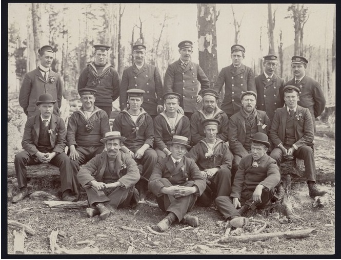 A black and white photo of the crew of SY Morning on a picnic in woodland at Otarama, New Zealand in 1902.