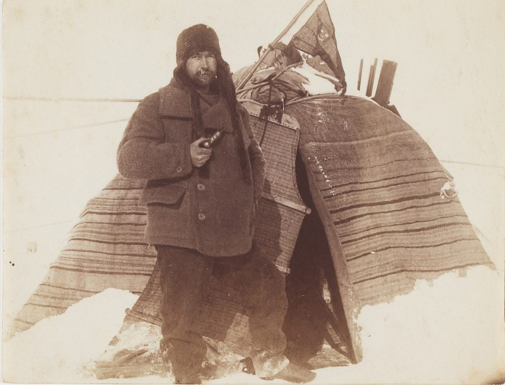 William Colbeck with a pipe outside Lap tent, British Antarctic (Southern Cross) Expedition, 1898-1900,