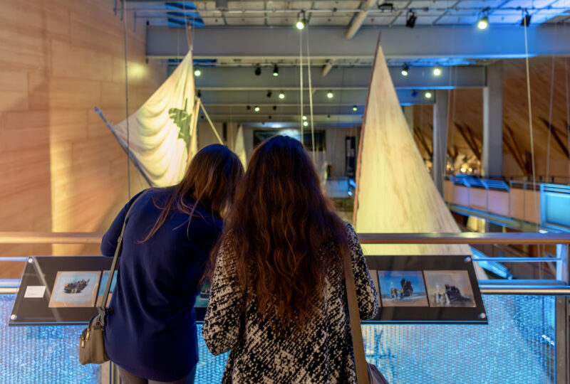 Two women looking at paintings in a gallery.