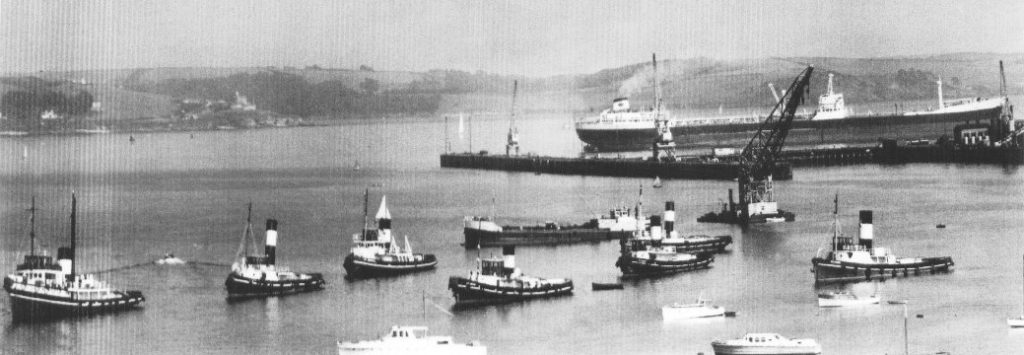 A black and white photo of all seven Falmouth Harbour steam tugs in the harbour taken in c1955.