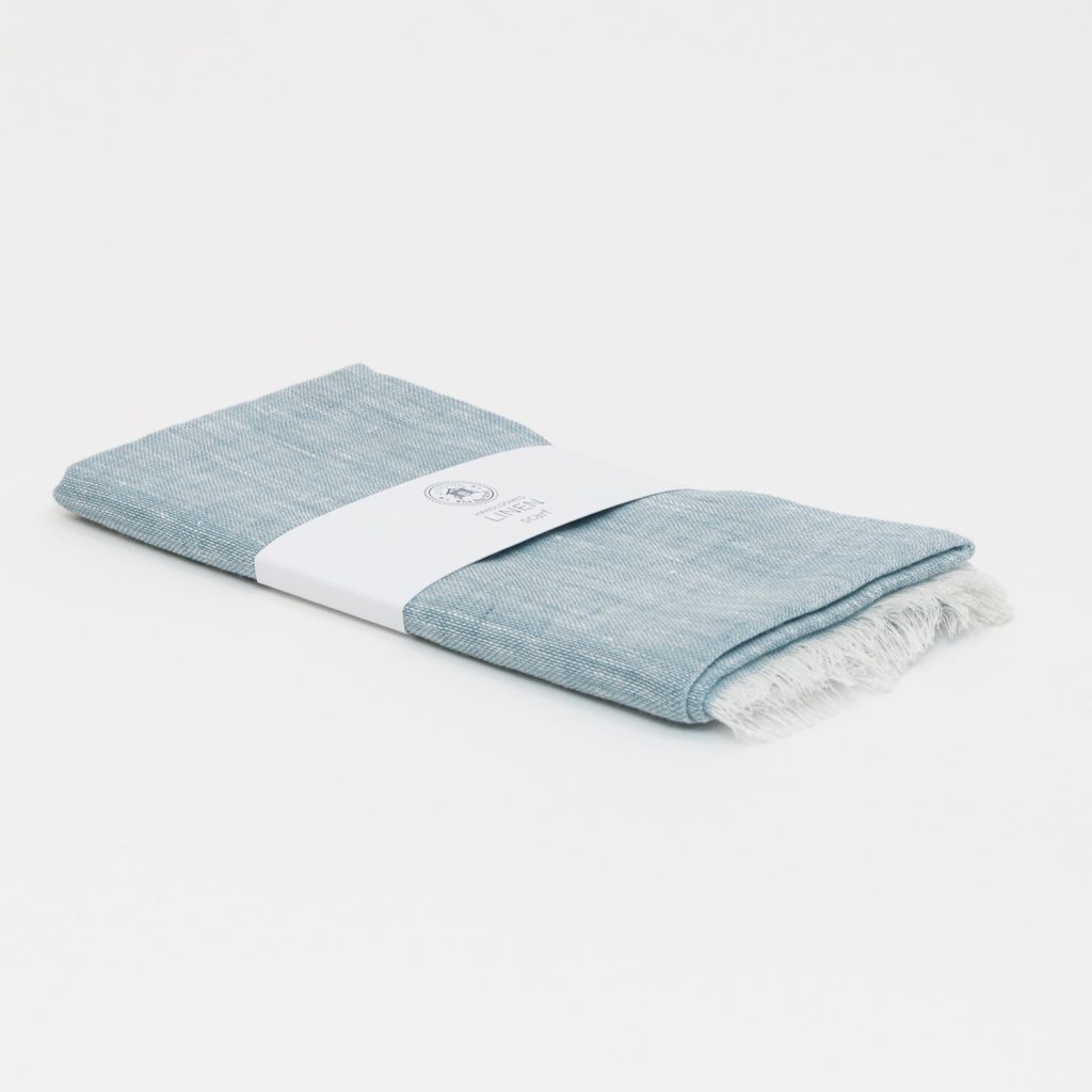 A sea blue linen scarf on a white background.